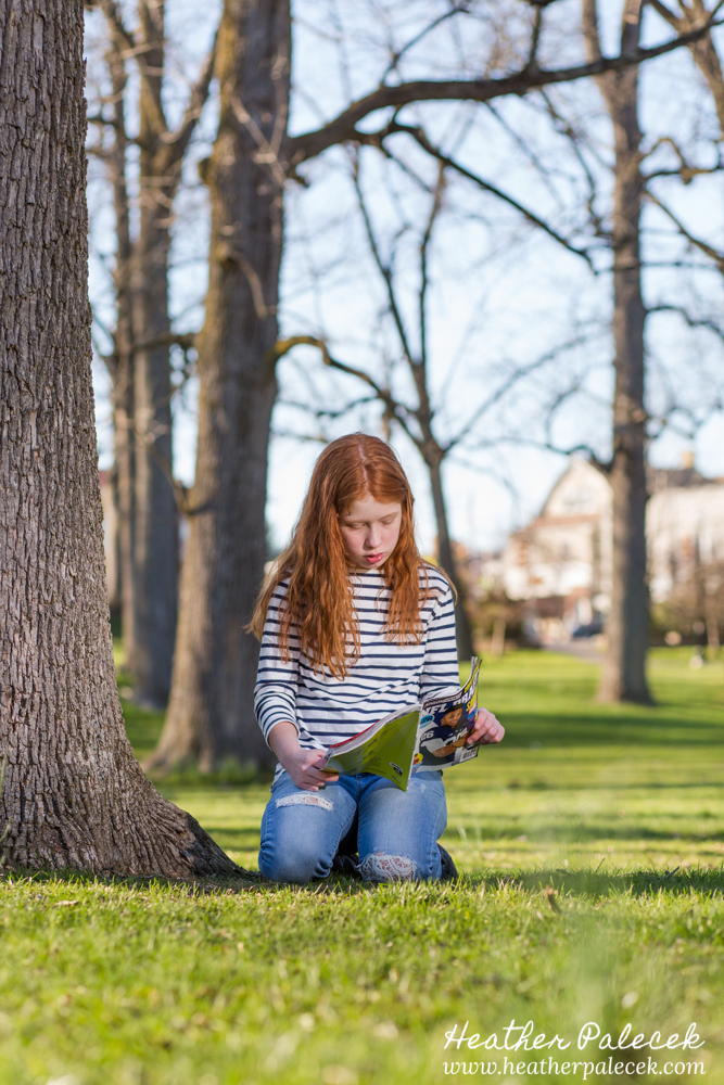girls reading book in park