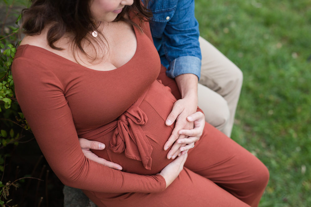 detail photo of parents holding baby bump