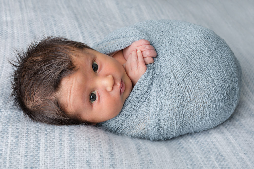 newborn boy in blue wrap