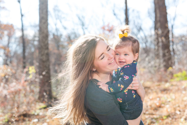 mom and daughter posing outdoors in fall