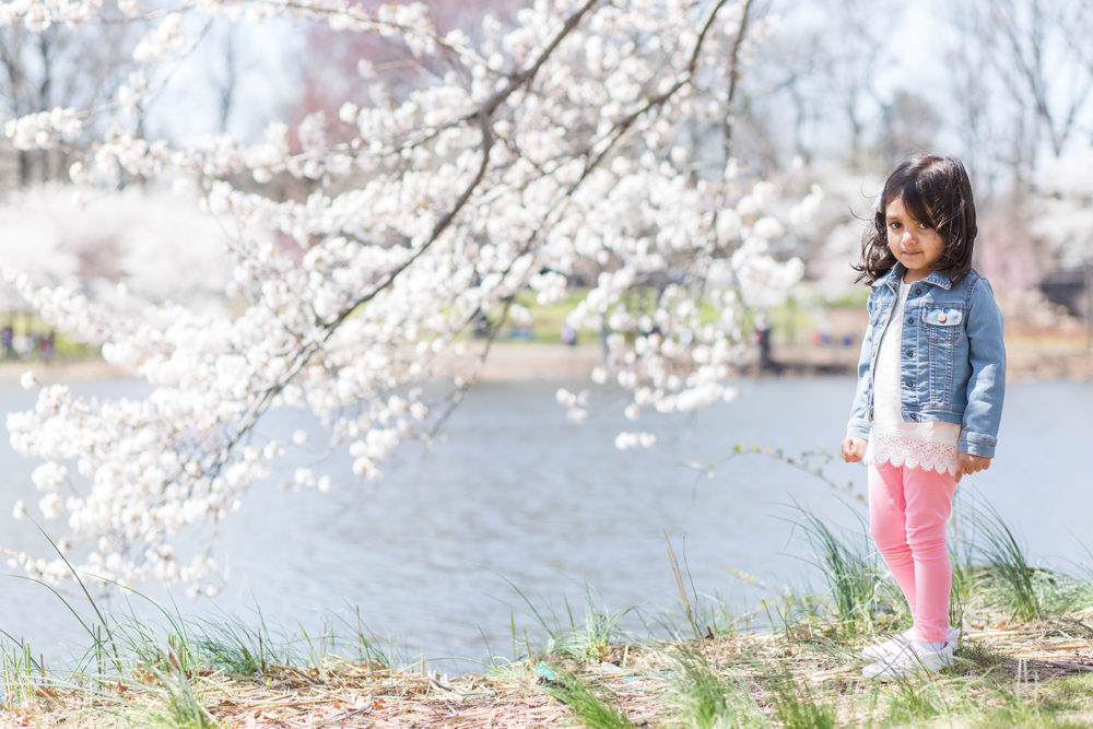 girl posing next to cherry blossom tree