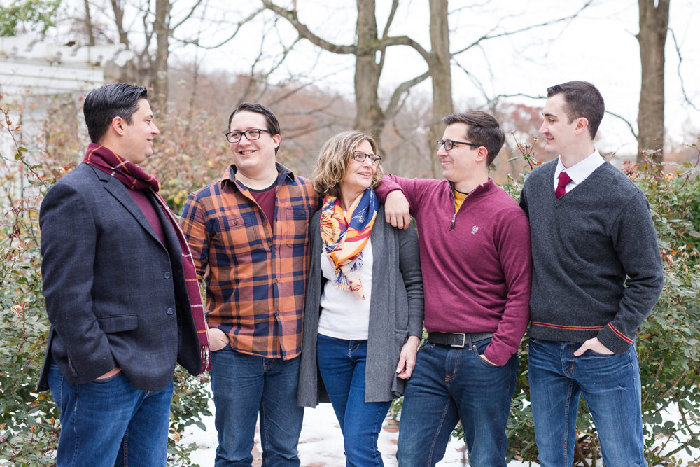 mom and four boys pose outdoors in snow