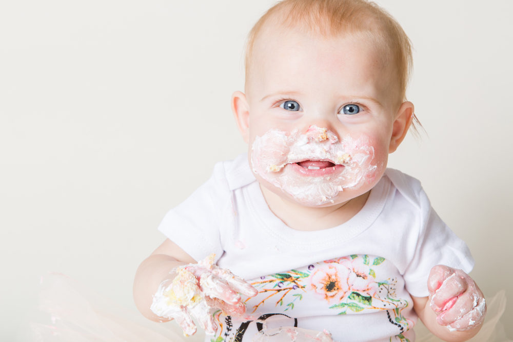 kid with cake all over face after cake smash