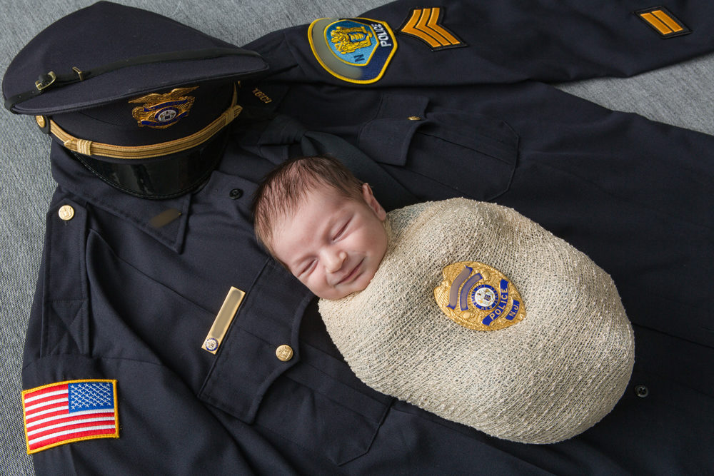 newborn baby on police uniform