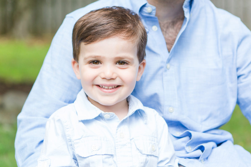 Boy in blue sitting on dads lap