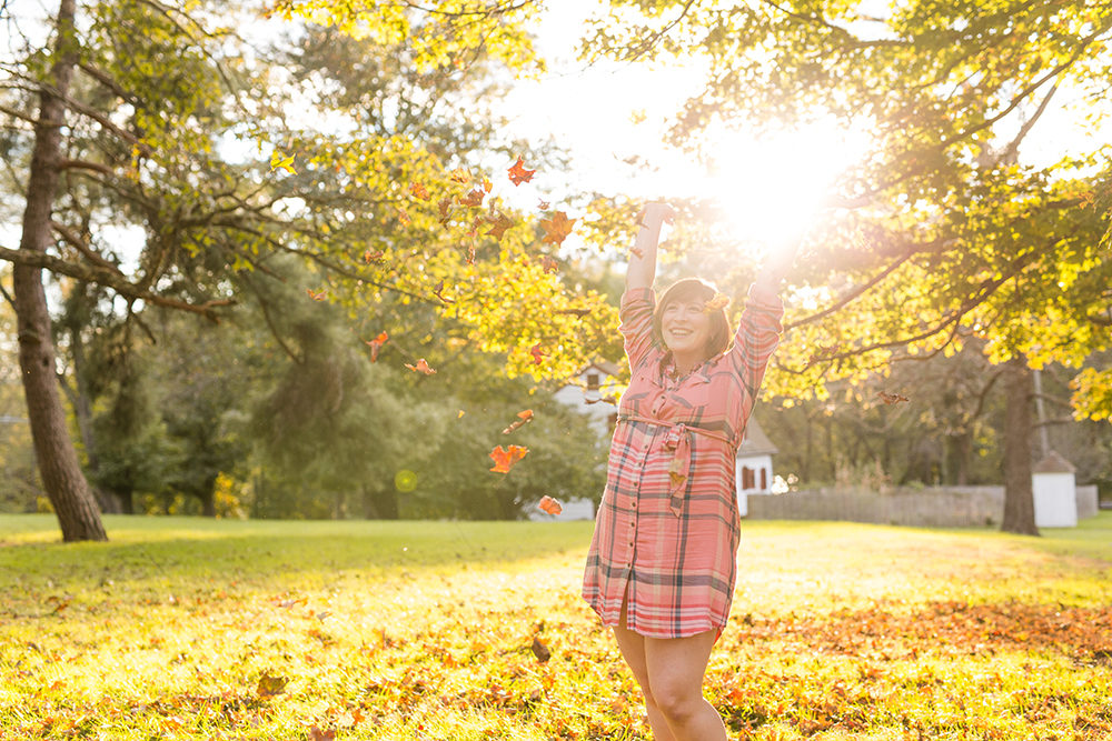 pregnant woman throws leaves