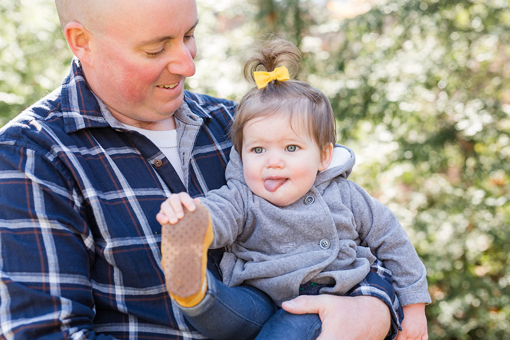 dad holds daughter making a funny face