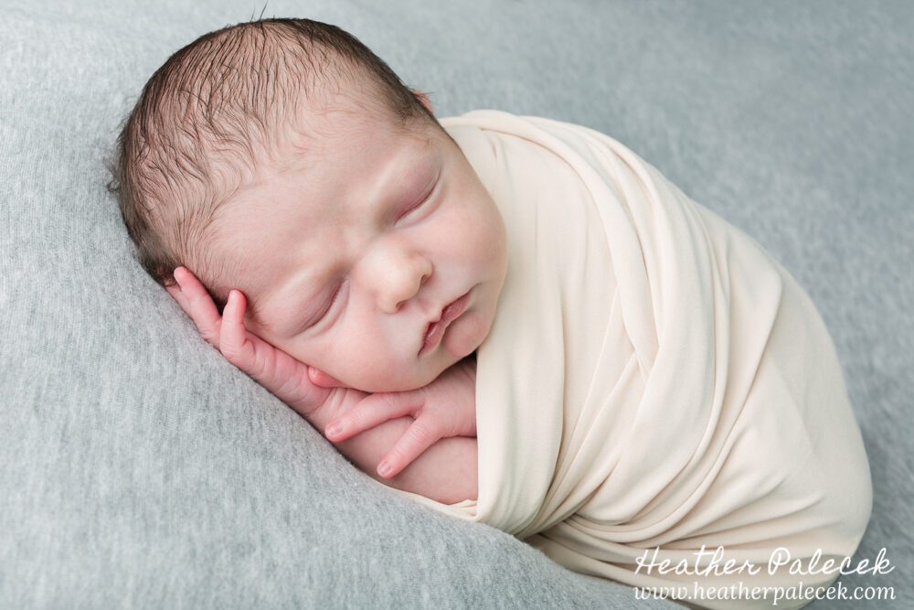 newborn boy wrapped in neutral colors