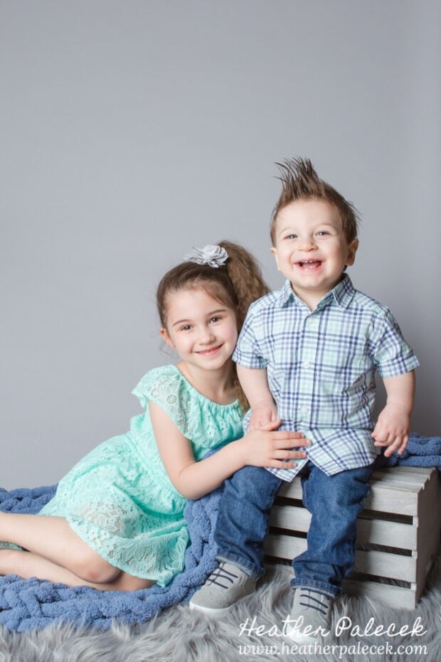 brother and sister portrait in studio with gray background
