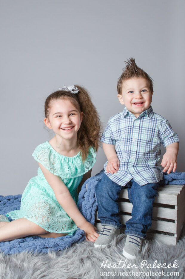 brother and sister portrait in studio with gray background