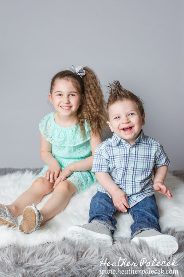 brother and sister portrait in studio with gray background