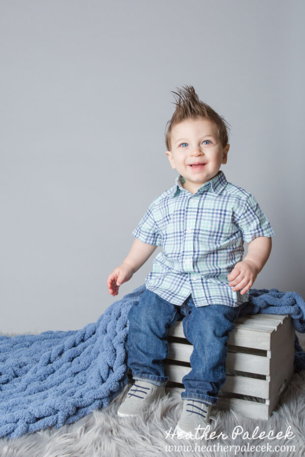 first birthday portrait of boy in blue button down