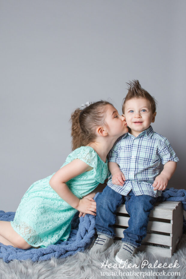 brother and sister portrait in studio with gray background