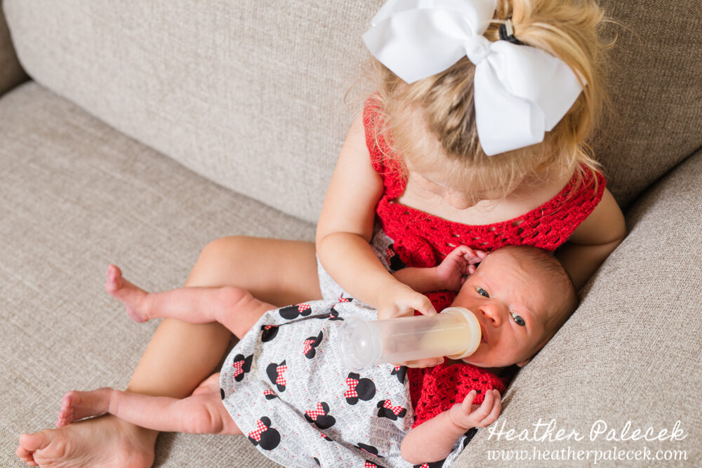 sister feeding newborn sister
