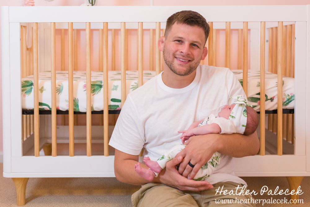 mom holds newborn in cactus themed nursery