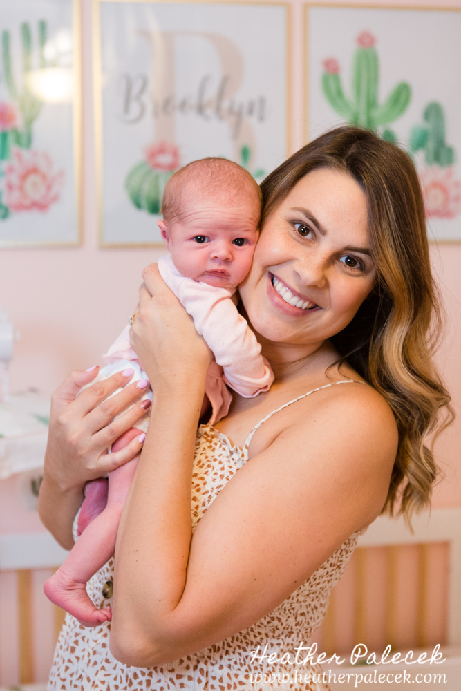 mom holds newborn in cactus themed nursery
