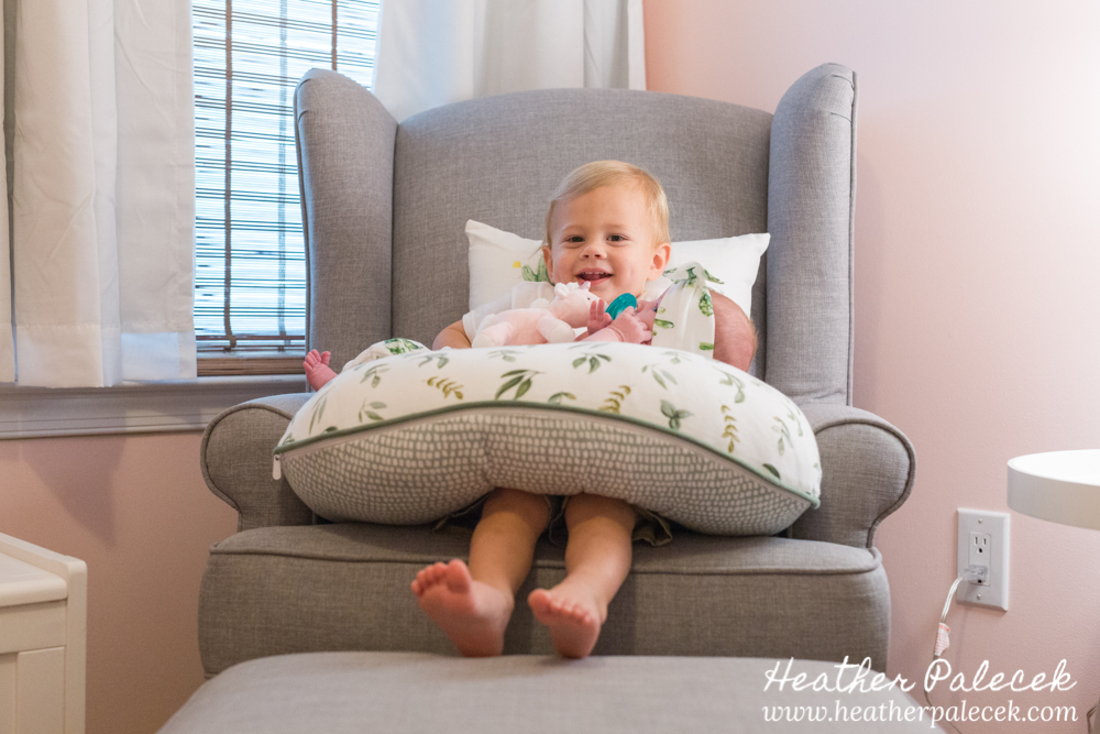 brother holds baby sister in nursery
